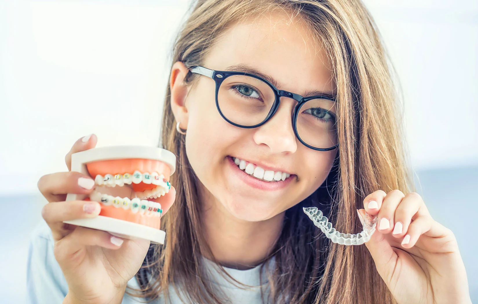 Girl holding Invisalign and braces in Los Angeles, CA